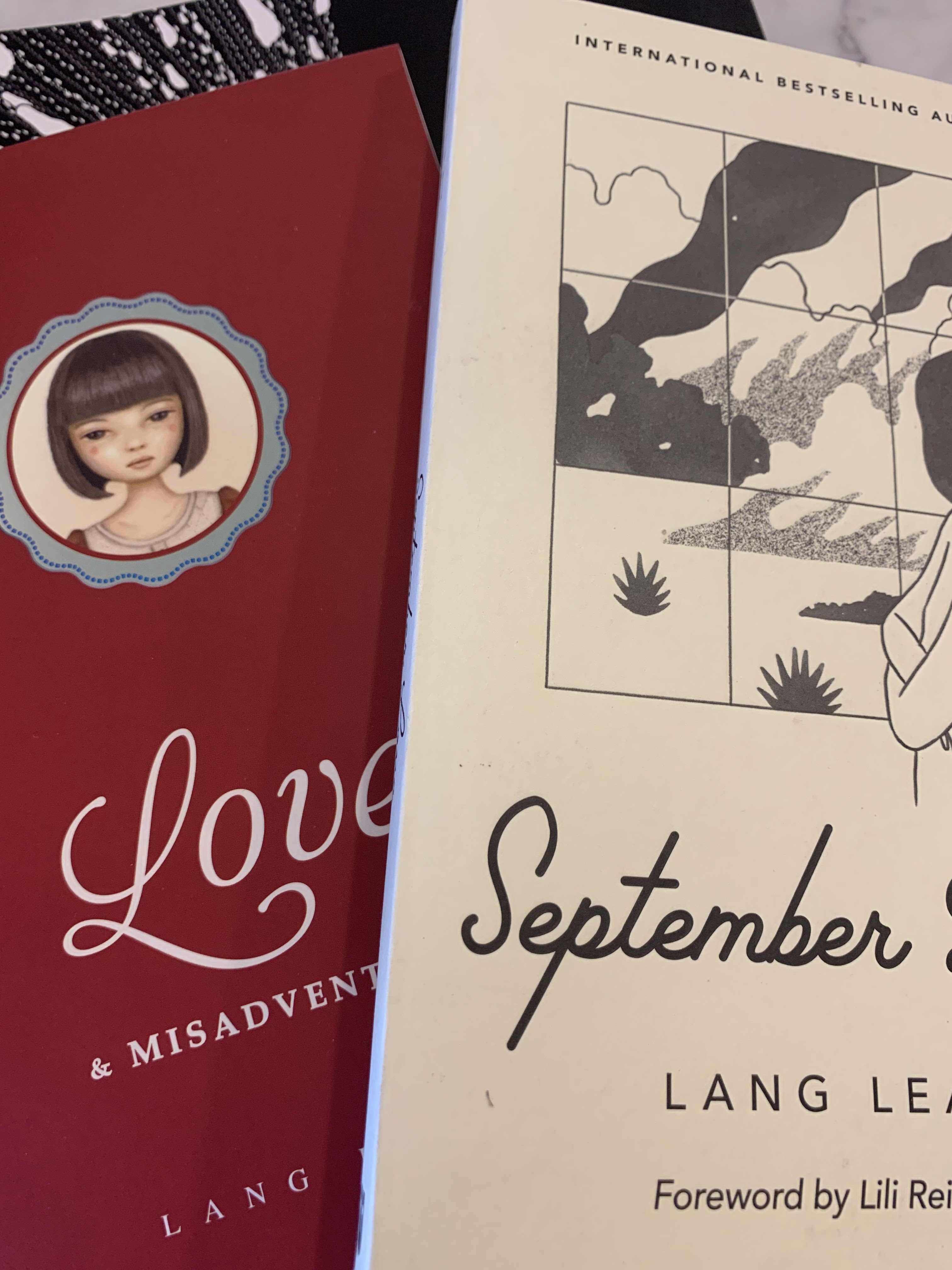 Two books of poetry: the lefthand one is red and is entitled "Love"; the right hand one is cream and we can see the word "September" in the title.
